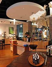 Modern spa reception area with wooden floors, a front desk, retail shelves, and a prominent white orchid in the foreground. - Varuna Salon Spa in Annapolis, MD