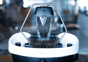 A close-up view of a modern salon hair-washing station with water flowing from a spout into a white basin, capturing the luxurious experience of a Japanese Head Spa in Annapolis. - Varuna Salon Spa in Annapolis, MD